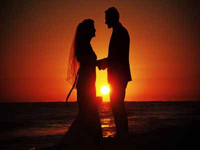 couple in front of sunset holding hands